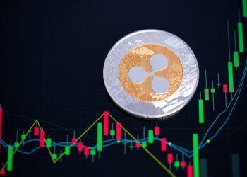 Una moneda de XRP (Ripple) junto con un gráfico al alza