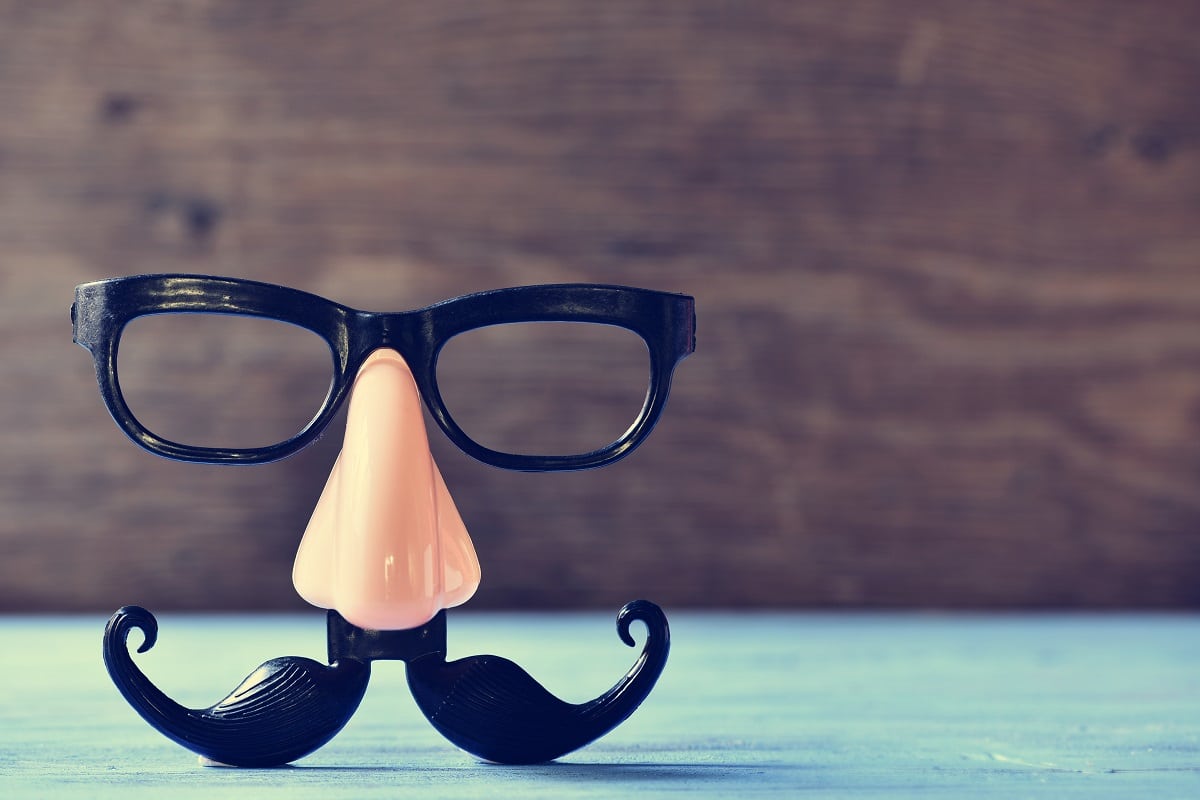 a fake mustache, nose and eyeglasses on a rustic blue wooden surface