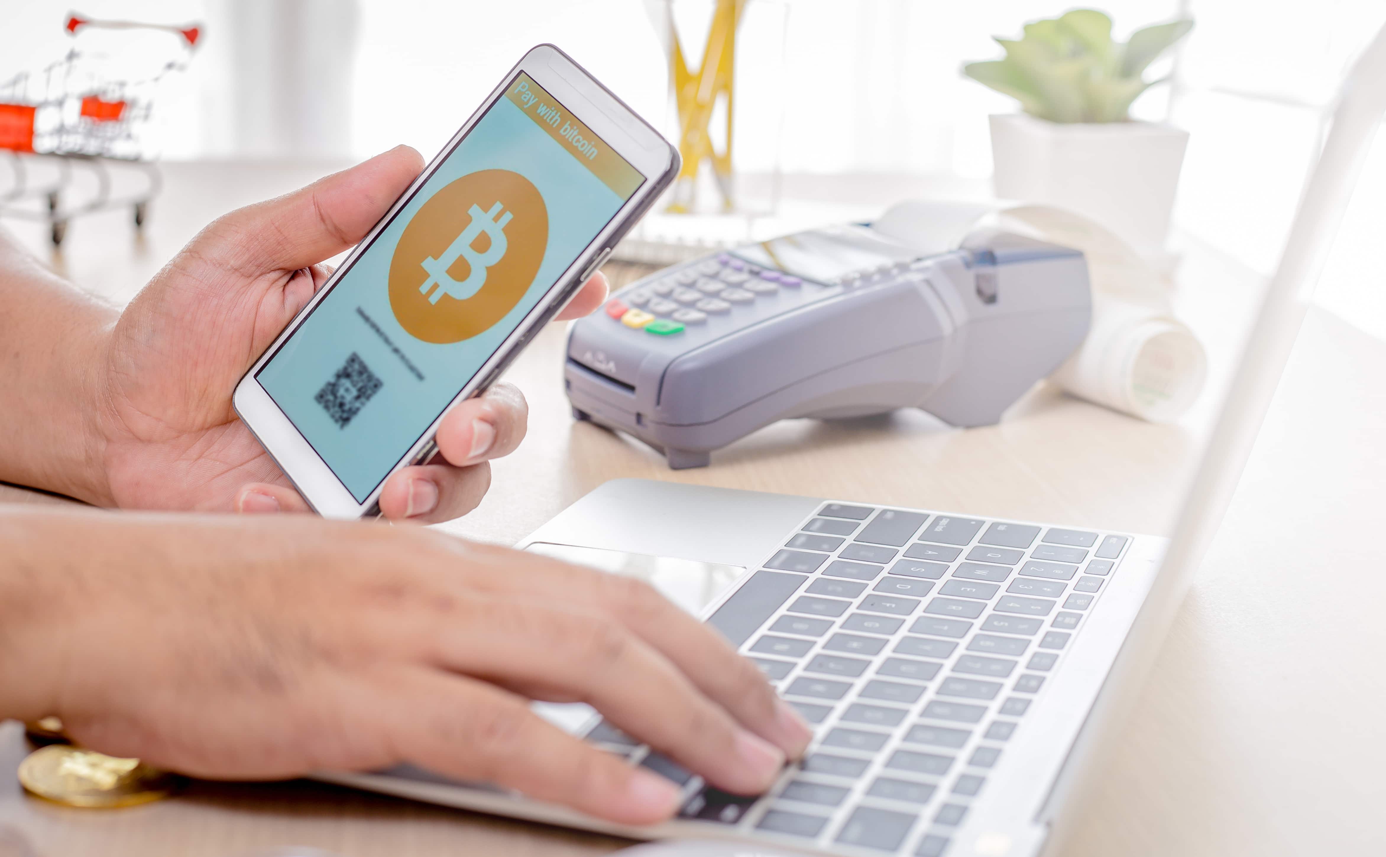 Man use smart phone pay with bitcoin