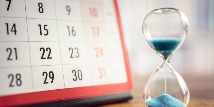 Hour glass and calendar concept for time slipping away for important appointment date, schedule and deadline