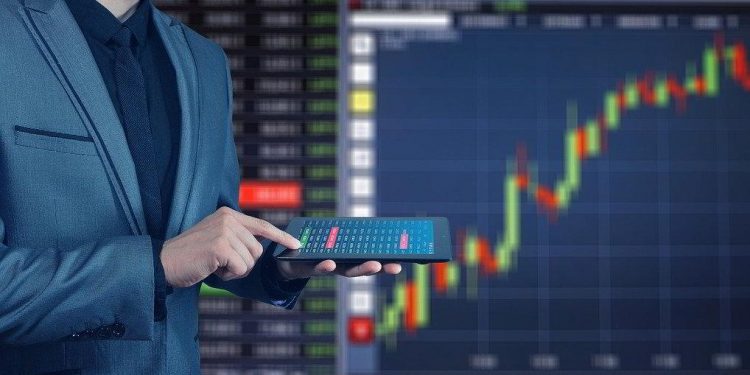 Trader con tableta frente a gráfico bursátil. Imagen de Gerd Altmann en Pixabay