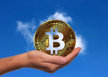 Bitcoin siendo alzado por una mano en un cielo despejado. Fuente: geralt/ Pixabay.com