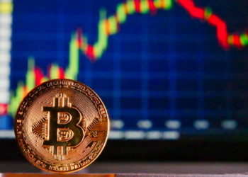 Un bitcoin delante de una gráfica de mercado de valores. Fuente: RoyBuri.