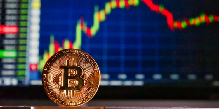 Un bitcoin delante de una gráfica de mercado de valores. Fuente: RoyBuri.