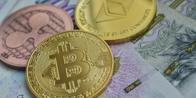 Bitcoin, Ripple y Ether en una mesa junto a dinero fiat. Funte: vjkombajn/ Pixabay.com