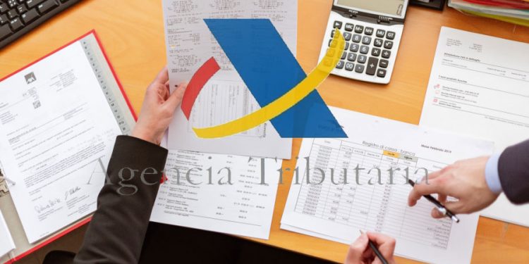 Logo de la Agencia Tributaria de España sobre escritorio. Imágenes de agenciatributaria.es y Oleg Magni / pexels.com