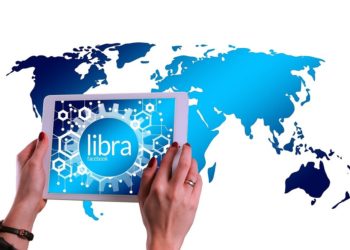 Tableta con alusión a Libra, de Facebook, sobre mapa del mundo. Fuente:  Gerd Altmann/pixabay.com