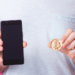 Un hombre enseña su bitcoin y teléfono celular. Fuente: Satura_/ Envato Elements.