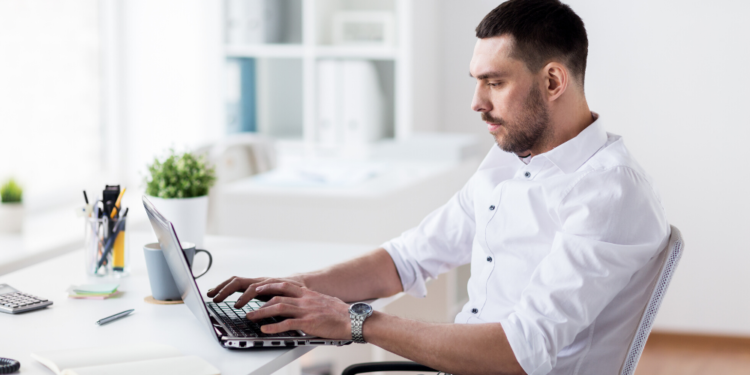 Una persona escribiendo en su computadora. Fuente: dolgachov/ Envato Elements.