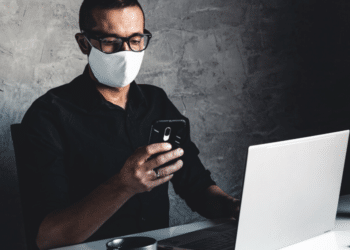 Un hombre trabaja con mascarilla para protegerse del coronavirus. Fuente: serbogachuk/ Envato Elements.