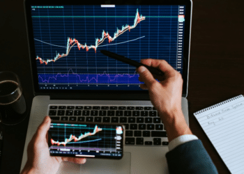 Un hombre de negocios revisa el precio de un activo en el mercado. Fuente: avanti_photo/ Envato Elements.