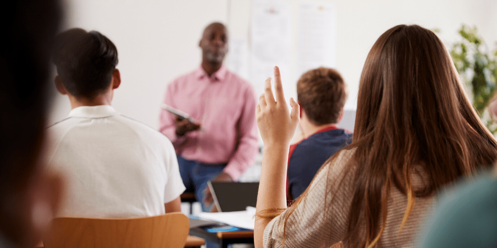 Una joven universitaria interviene en clase. Fuente: monkeybusiness/ Envato Elements.