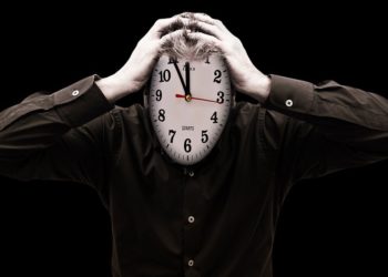 Hombre con cara de reloj sujetándose la cabeza con ambas manos. Fuente: Gerd Altmann / Pixabay