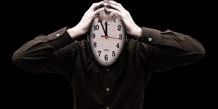 Hombre con cara de reloj sujetándose la cabeza con ambas manos. Fuente: Gerd Altmann / Pixabay