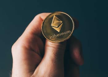 Hombre sosteniendo una moneda de ethereum sobre su pulgar. Fuente:  stevanovicigor /   elements.envato.com