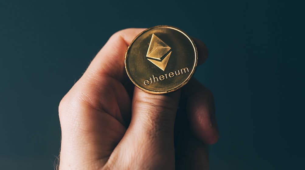 Hombre sosteniendo una moneda de ethereum sobre su pulgar. Fuente:  stevanovicigor /   elements.envato.com