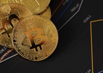 Criptomonedas bitcoin encima de estadísticas y gráficos financieros. Fuente: kjekol/elements.envato.com