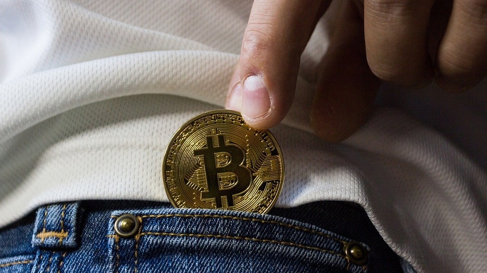 Hombre introduciendo bitcoin en su bolsillo. Fuente: WorldSpectrum / Pixabay