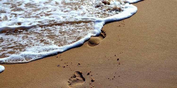 Huellas en la arena siendo borradas por el mar. Fuente: Thomas Gerlach /  Pixabay.com