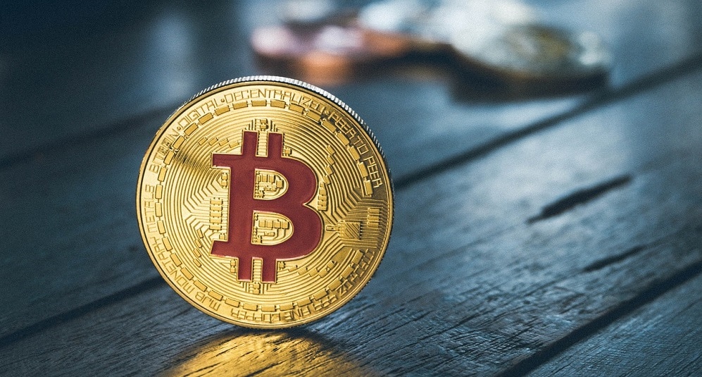 Moneda de Bitcoin sobre una mesa. Fuente: pattymalajak / Pixabay