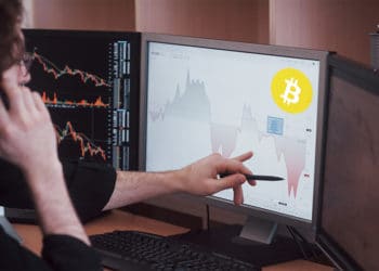 Trader señalando gráfico en pantalla con logo de Bitcoin. Composición por CriptoNoticias. WikimediaImages / Pixabay.com ; mstandret / elements.envato.com