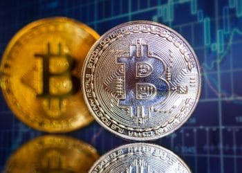 Monedas de Bitcoin frente a gráfico de velas en el fondo. Fuente: erika8213 / elements.envato.com