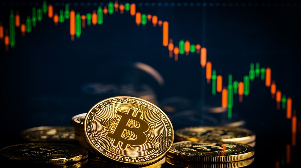 Monedas de Bitcoin frente a gráfico bajista del mercado. Fuente: jirkaejc / elements.envato.com