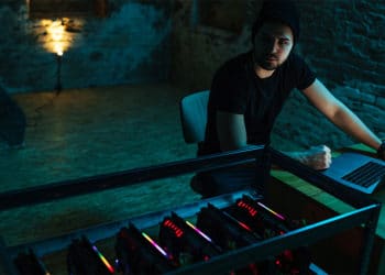 Hombre en la oscuridad con mineros de criptomonedas. Fuente: bernardbodo / elements.envato.com