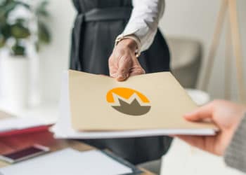 Mujer entregando carpeta con documentos con logo de Monero. Composición por CriptoNoticias. LightFieldStudios / elements.envato.com; Monero /  getmonero.org.