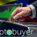 Logo de Cryptobuyer frente a hombre pagando con moneda de Bitcoin con gráfico alcista y bandera de Venezuela en el fondo. Composición por CriptoNoticias. cryptobuyer / cryptobuyer.io; master1305 / freepik.com;  leungchopan / elements.envato.com; wirestock / Freepik.com.