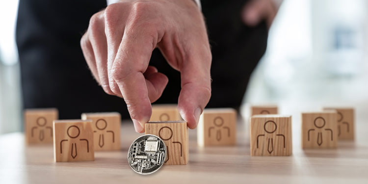 Criptomoneda apoyada sobre pieza de madera siendo seleccionada por empresario. Composición por CriptoNoticias. johan10 / elements.envato.com; Gajus-Images / elements.envato.com.