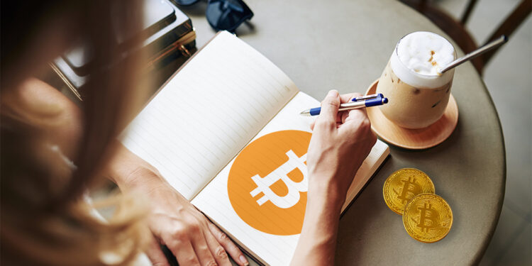 Mujer con logo de bitcoin dibujado en libreta junto a monedas de bitcoin. Composición por CriptoNoticias. kjekol / elements.envato.com; Bitcoin / wikipedia.org; DragonImages / elements.envato.com.