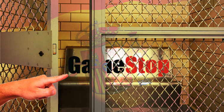 Mano señala celda con logo de GameStop y bandera de España superpuesta. Composición por CriptoNoticias. Tumisu / pixabay.com; GameStop / gamestop.com; wirestock / freepik.com; Mint_Images / elements.envato.com.