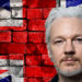 Julian Assange frente a pared de ladrillos con bandera de Reino Unido pintada. Composición por CriptoNoticias.lawyers Weekly / lawyersweekly.com; twenty20photos / elements.envato.com.