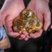 Rodolfo Andragnes junto a Franco Amati con hombre ofreciendo monedas de Bitcoin en el fondo. Composición por CriptoNoticias. Rodolfo Andragnes / linkedin.com; Franco Amati / facebook.com; grafvision / elements.envato.com.