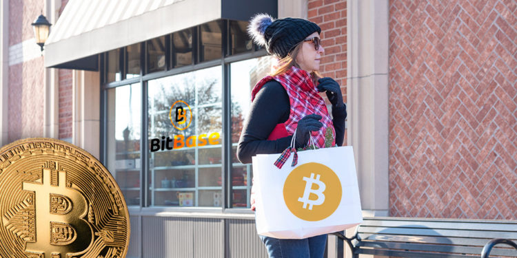 Mujer con bolsa de compras con logo de bitcoin con tienda de BitBase y moneda de Bitcoin en el fondo. Composición por CriptoNoticias. Bitcoin / bitcoin.org; LightFieldStudios / elements.envato.com; BitBase / bitbase.es; twenty20photos / elements.envato.com.