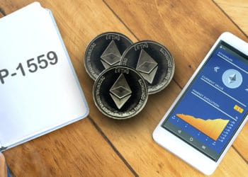 Libreta con EIP-1559, monedas de Ethereum con estatus de criptomoneda en celular.