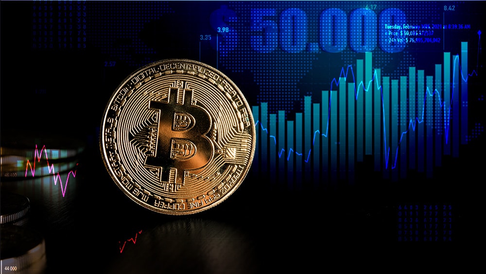 Moneda de Bitcoin con gráfico alcista del precio marcando USD 50.000 en el fondo