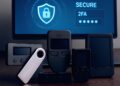 Varias wallets de hardware una al lado de la otra y pantalla azul al fondo