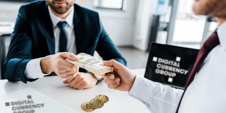 Empresarios con dólares, logo de Digital Currency Group, y bitcoins.