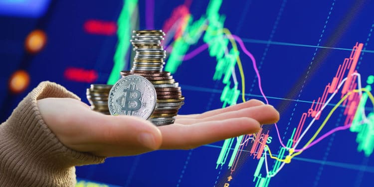 Gráfico bursátil y mano sosteniendo pila de bitcoins.