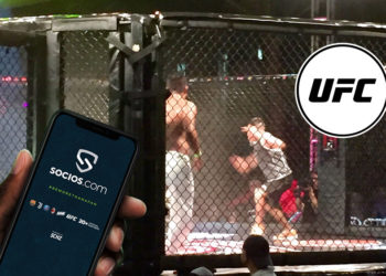 Pelea de UFC con su respectivo token y mano sosteniendo teléfono con pantalla de socios.com.