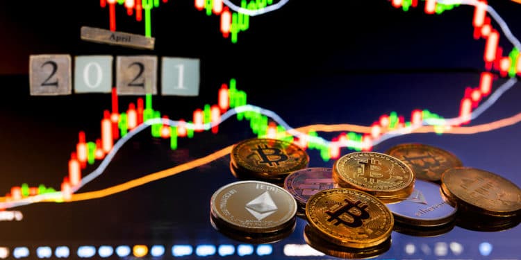 Gráfico bursátil con bitcoins y cubos de madera que denotan abril 2021.