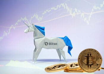 Unicornio de origami con logo de Bitso, unas bitcoins en el suelo y gráfico bursátil.