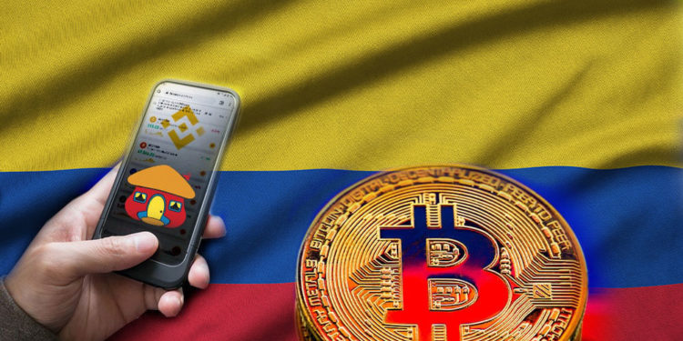 Bandera de Colombia y bitcoin, mano sosteniendo teléfono con app de Binance, su logo y logo de Davivienda.