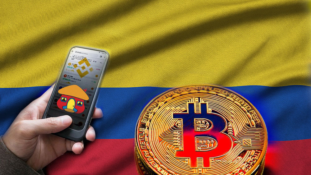 Bandera de Colombia y bitcoin, mano sosteniendo teléfono con app de Binance, su logo y logo de Davivienda.