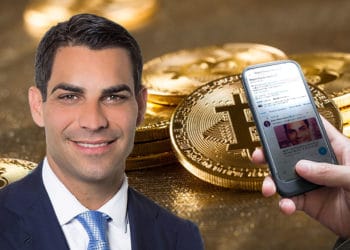 Alcalde Francis Suarez y mano que muestra tuir del mismo sobre fondo de bitcoins.