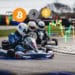 Kartings con bitcoin, ether, binance coin con gráfico bursátil en el ambiente.