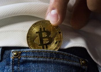 Metiendo en el bolsillo del pantalón un bitcoin