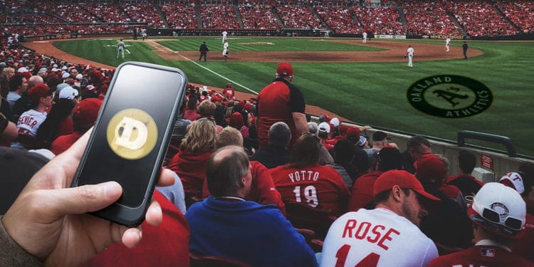 Estadio de beisbol de los Atléticos de Oakland y mano sosteniendo teléfono con dogecoin.